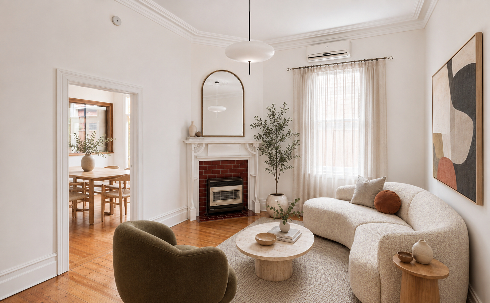After virtual staging: contemporary furnished living room featuring low-profile sofa, designer rug, coffee table, and curated artwork